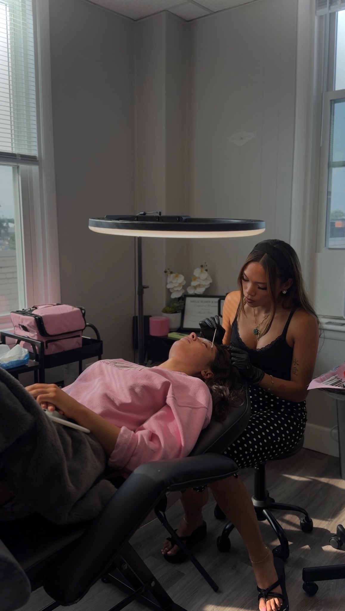 Abigaille caring for a client during a brow appointment in her private studio